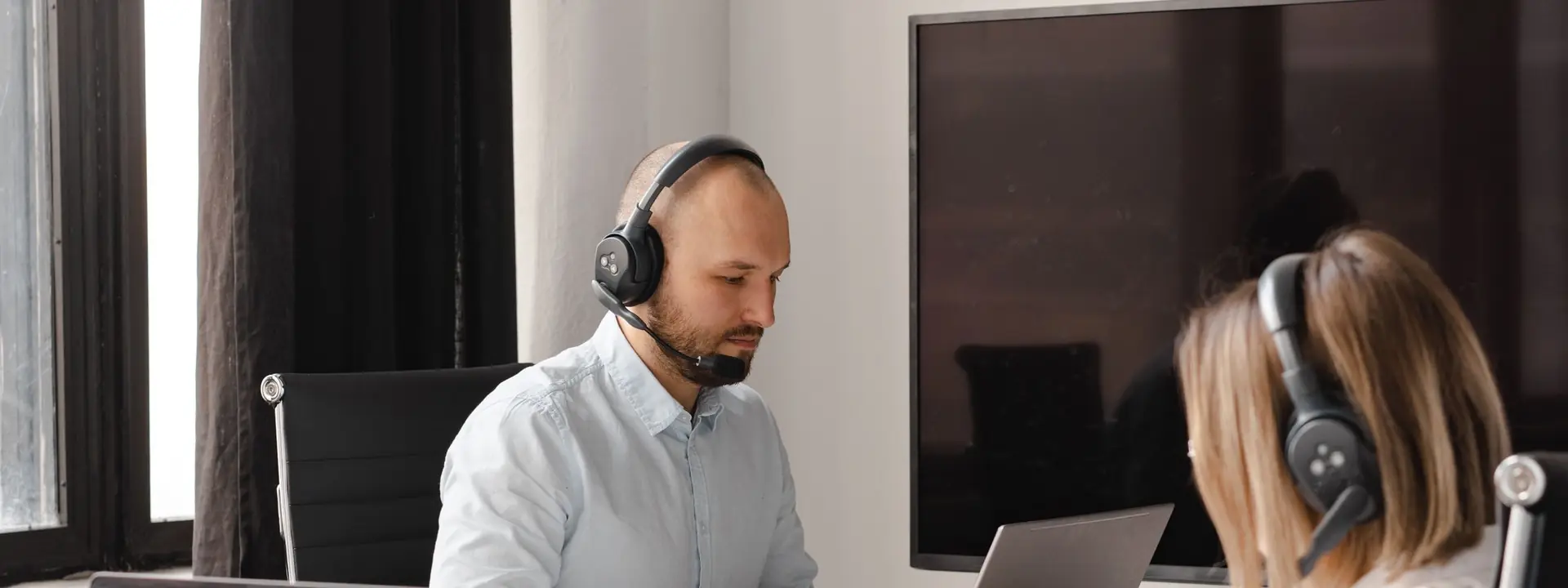 Outbound call center agents working through a B2B dialling list together at a shared workstation