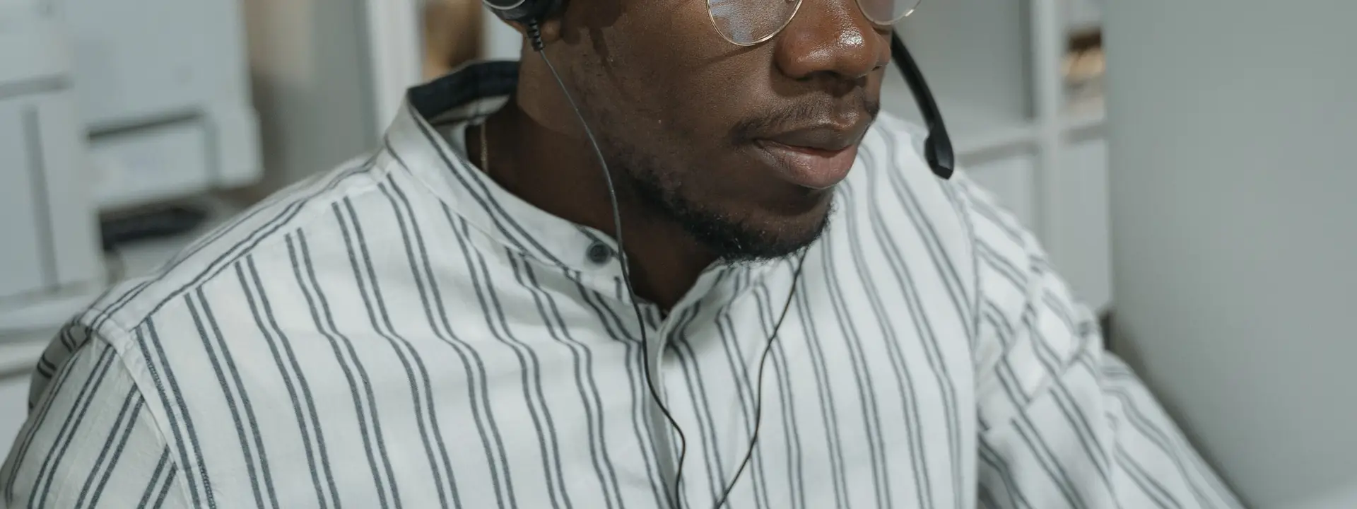 Outsourced technical support engineer in a headset working a customer troubleshooting ticket